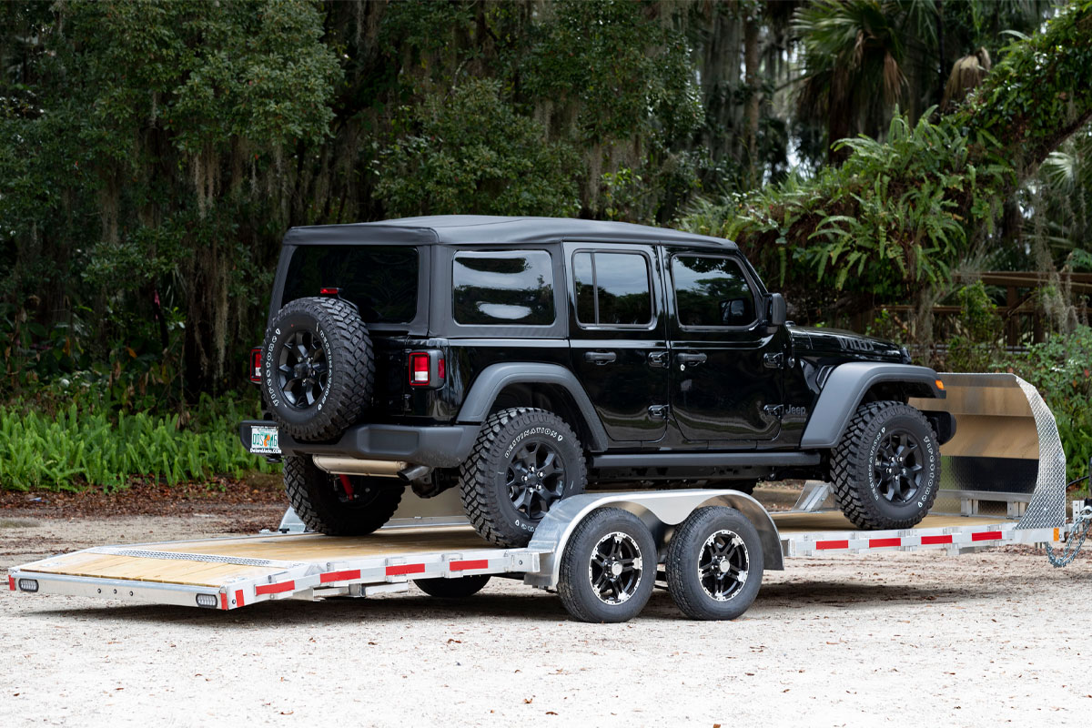 Black Jeep Loaded Onto Open Wood Deck Car Hauler