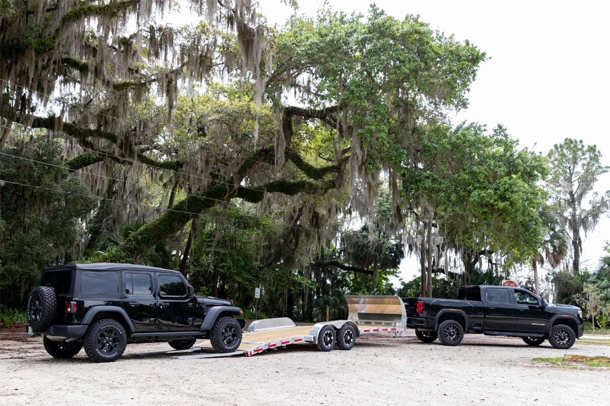 Black Jeep Loading Onto Open Wood Deck Car Hauler